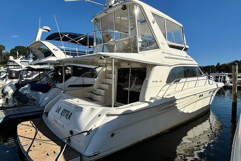 Slide: The Image of 1998 Sea Ray 480 Sedan Bridge yacht docked at marina under clear blue sky. - 42
