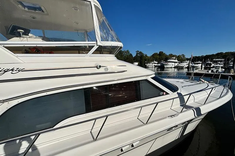 Slide: The Image of 1998 Sea Ray 480 Sedan Bridge yacht docked at marina under clear blue sky. - 5