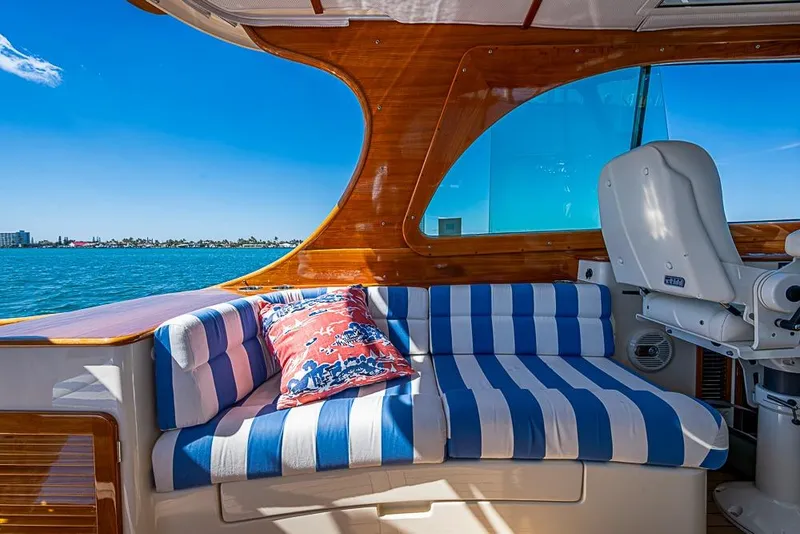 Slide: The Image of 2016 Hinckley Picnic Boat MKIII interior with striped seating and scenic ocean view. - 10