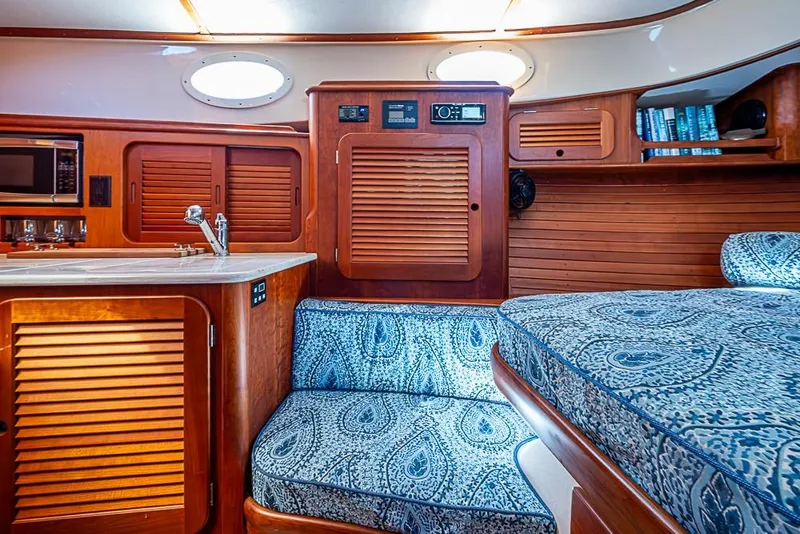 Slide: The Image of Interior of 2016 Hinckley Picnic Boat MKIII with wood paneling and patterned seating. - 16
