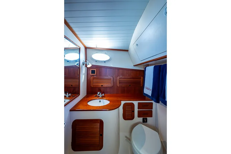 Slide: The Image of 2016 Hinckley Picnic Boat MKIII bathroom with wooden cabinetry and modern fixtures. - 18