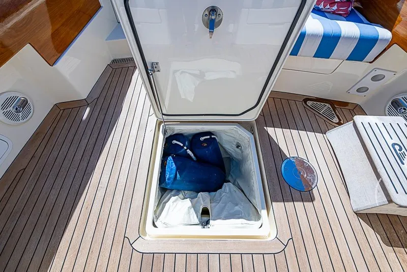 Slide: The Image of 2016 Hinckley Picnic Boat MKIII storage compartment with open hatch on teak deck. - 6