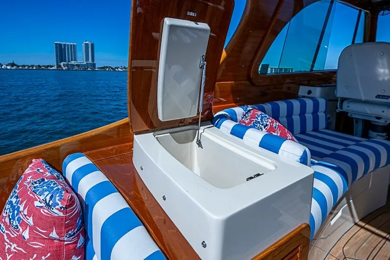 Slide: The Image of 2016 Hinckley Picnic Boat MKIII interior with striped seating and open storage compartment. - 7