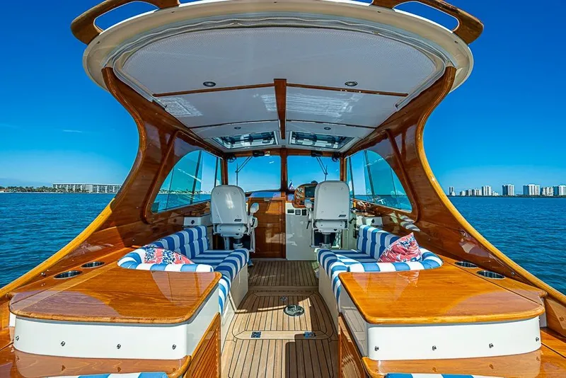 Slide: The Image of 2016 Hinckley Picnic Boat MKIII interior with striped seating, wooden finish, and ocean view. - 9