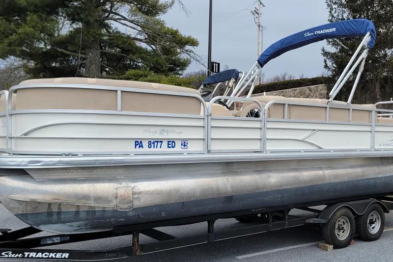 The Image of 2017 Sun Tracker Party Barge 24 DLX pontoon boat on trailer, parked outdoors. - 0
