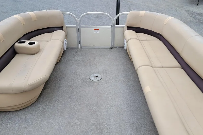Slide: The Image of 2017 Sun Tracker Party Barge 24 DLX interior with beige seating and cup holders. - 10