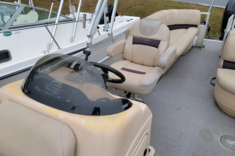 Slide: The Image of 2017 Sun Tracker Party Barge 24 DLX interior with beige seating and steering console. - 5