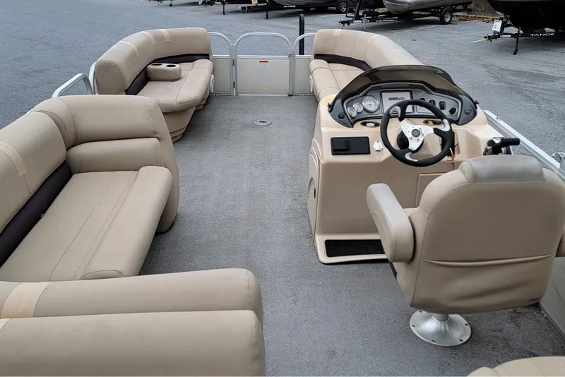 Slide: The Image of 2017 Sun Tracker Party Barge 24 DLX interior with beige seating and steering console. - 9