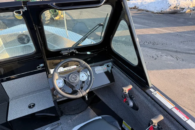 Slide: The Image of 2026 Crestliner 1850 Commander Elite boat cockpit with steering wheel and control panel. - 10