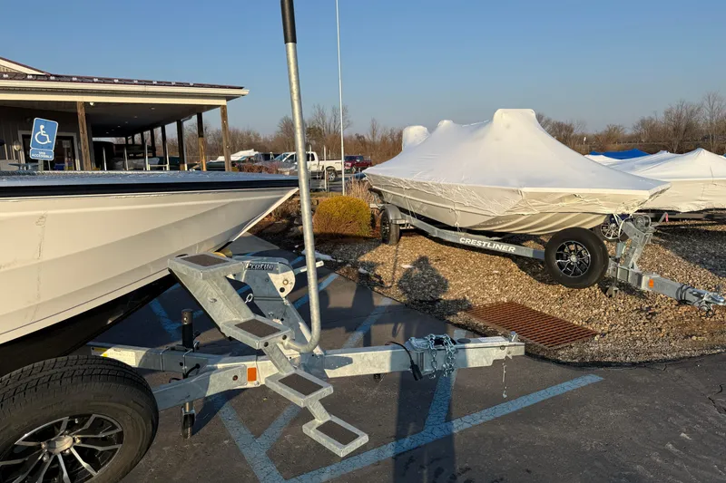 Slide: The Image of 2026 Crestliner 1850 Commander Elite boats on trailers, covered and parked outdoors. - 15