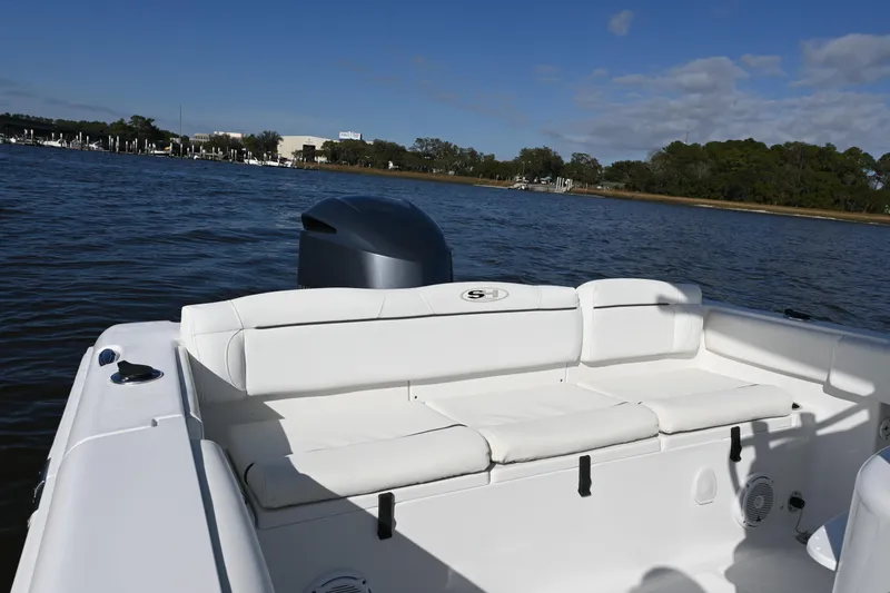 Slide: The Image of 2016 Sea Hunt Ultra 235 SE boat with white seating on calm water. - 10