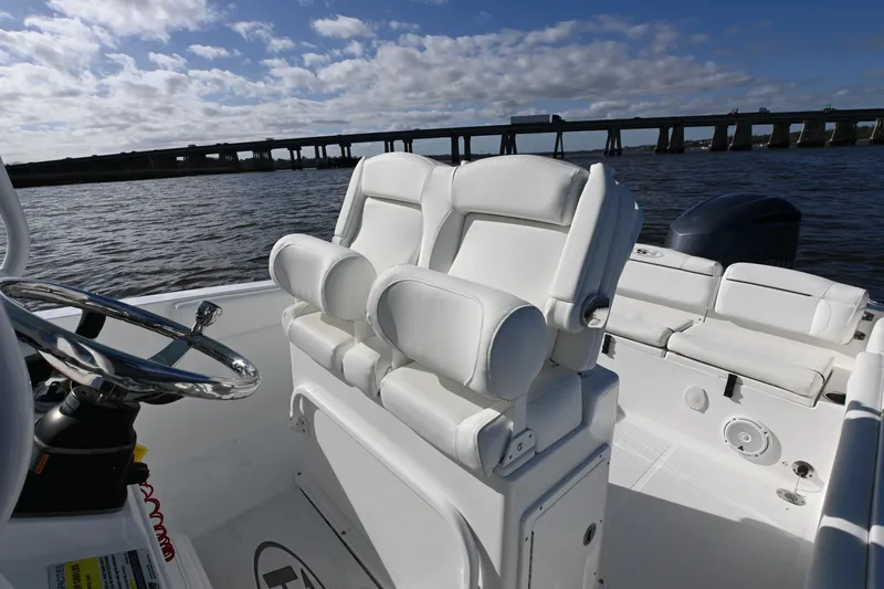 Slide: The Image of 2016 Sea Hunt Ultra 235 SE boat interior with white seating and steering wheel. - 11