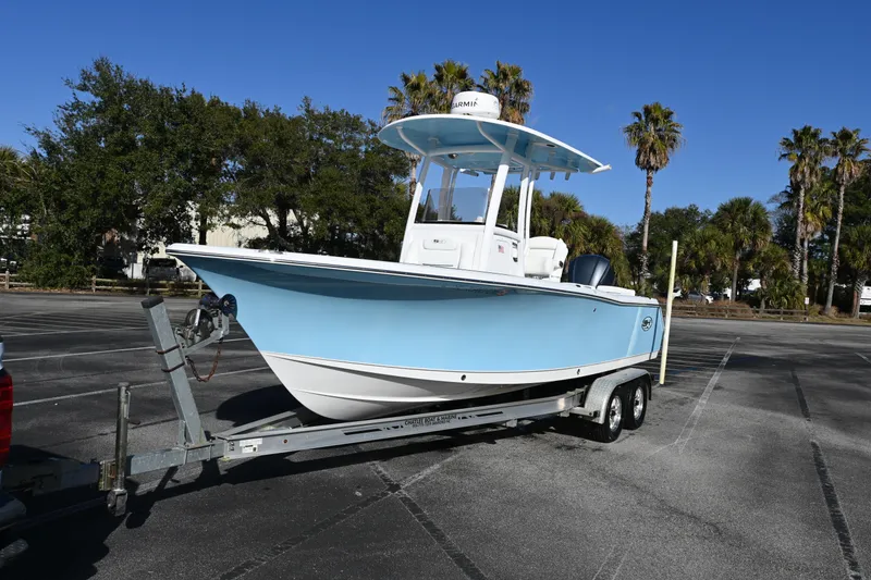 Slide: The Image of 2016 Sea Hunt Ultra 235 SE boat on trailer, parked outdoors under clear blue sky. - 20