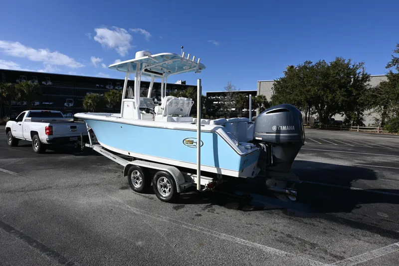 Slide: The Image of 2016 Sea Hunt Ultra 235 SE boat on trailer, parked in a lot under clear blue sky. - 21