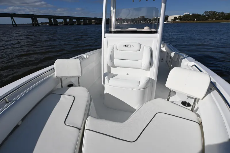 Slide: The Image of 2016 Sea Hunt Ultra 235 SE boat interior with white seating, on calm water. - 8