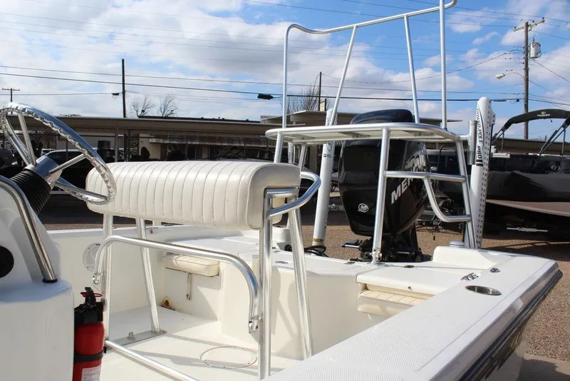 Slide: The Image of 2009 Kenner 2201 boat with steering wheel, seating, and Mercury engine in a marina setting. - 12