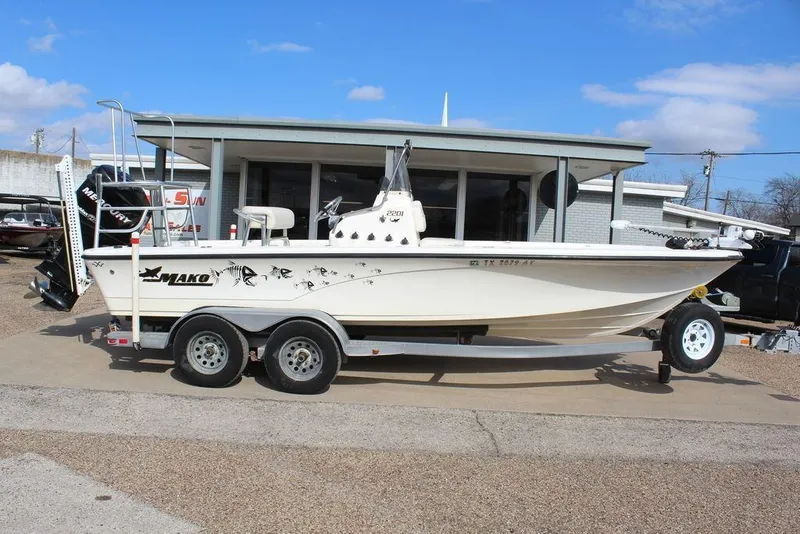Slide: The Image of 2009 Kenner 2201 boat on trailer, parked outside a building under a clear blue sky. - 5