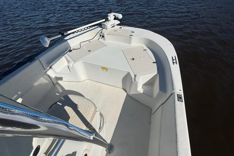 Slide: The Image of 2016 Carolina Skiff 198 DLV boat interior with storage compartments on calm water. - 10
