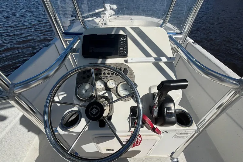 Slide: The Image of 2016 Carolina Skiff 198 DLV boat console with steering wheel and controls. - 12