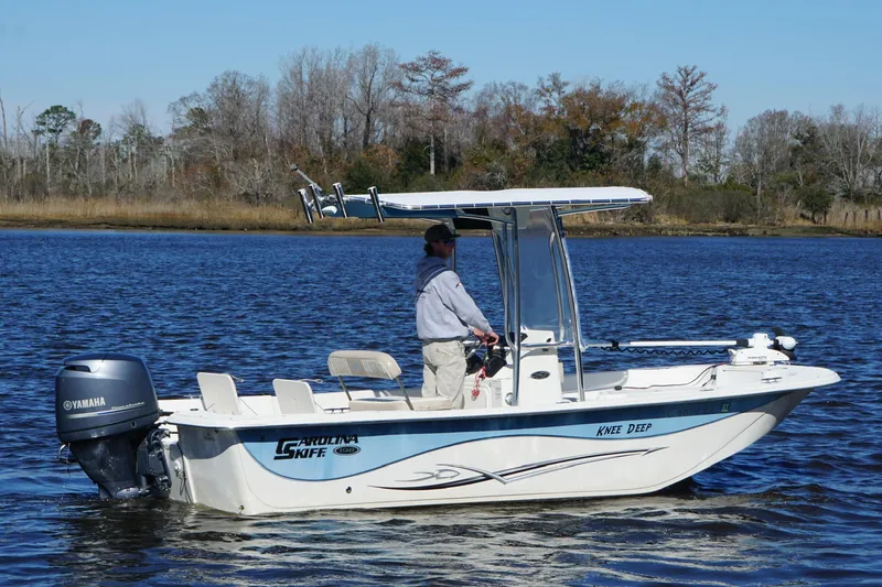 Slide: The Image of 2016 Carolina Skiff 198 DLV boat on calm water with Yamaha outboard motor. - 15