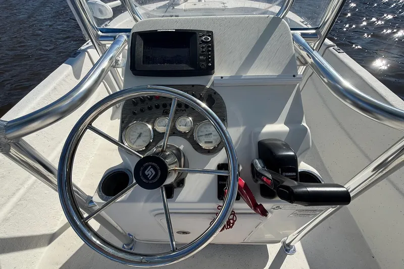 Slide: The Image of 2016 Carolina Skiff 198 DLV boat console with steering wheel and navigation controls. - 17