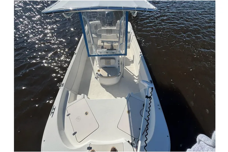 Slide: The Image of 2016 Carolina Skiff 198 DLV boat on water, featuring center console and spacious deck. - 6