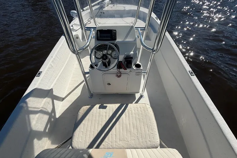 Slide: The Image of 2016 Carolina Skiff 198 DLV boat interior with steering console on sparkling water. - 8