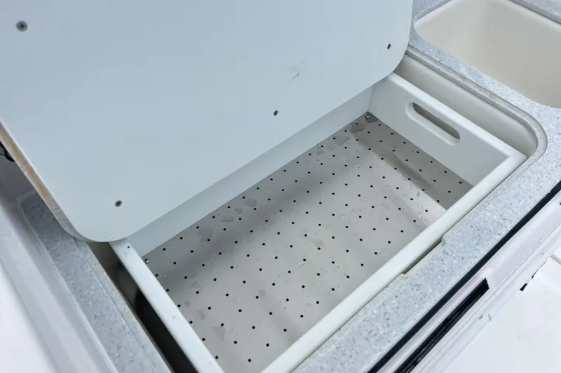 Slide: The Image of Open storage compartment on 2026 Sea Fox 328 Commander boat, featuring a perforated tray. - 24