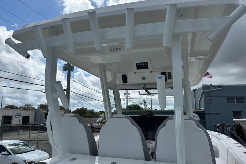 Slide: The Image of 2026 Sea Fox 328 Commander boat with T-top and rod holders, parked outdoors. - 42