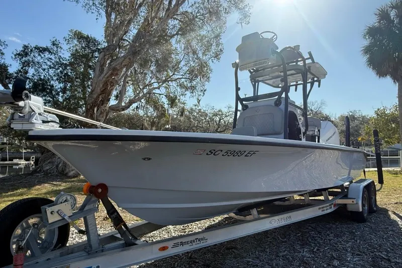 The Image of 2024 Xplor X24 boat on trailer, parked outdoors under sunny sky. - 1