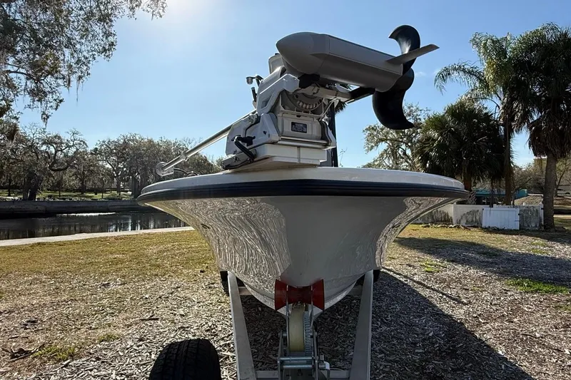 Slide: The Image of 2024 Xplor X24 boat on trailer, sunny day, surrounded by trees and water. - 12