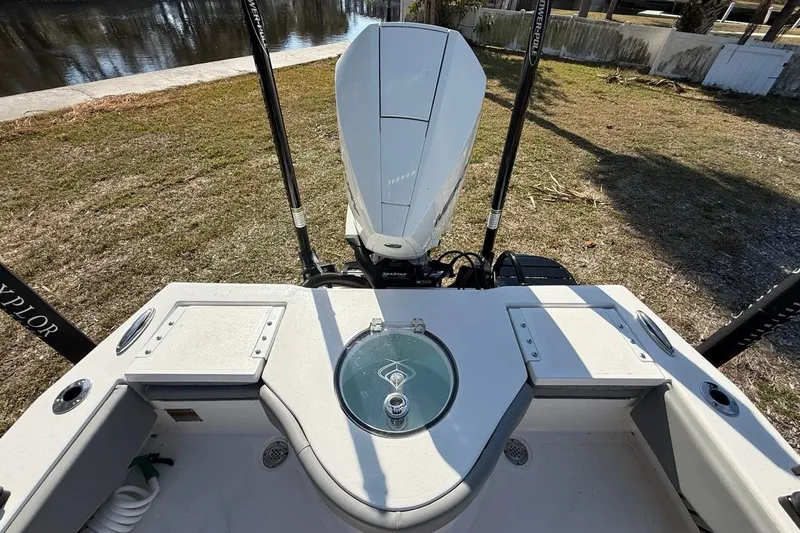 Slide: The Image of 2024 Xplor X24 boat stern view with motor and storage compartments. - 16