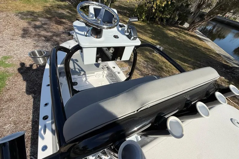 Slide: The Image of 2024 Xplor X24 boat interior with steering wheel and seating, near a waterway. - 29
