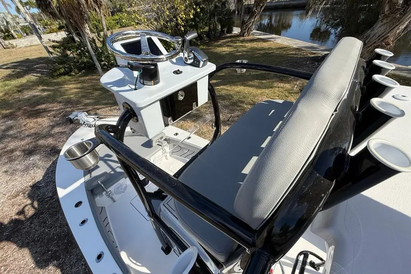 Slide: The Image of 2024 Xplor X24 boat interior with steering console and seating, near a waterway. - 30