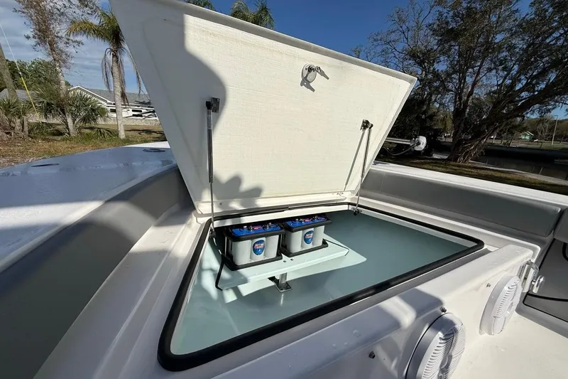 Slide: The Image of Open storage compartment on 2024 Xplor X24 boat, showcasing battery setup. - 37