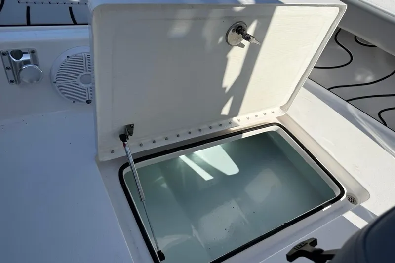 Slide: The Image of Open storage compartment on 2024 Xplor X24 boat deck with key lock. - 39
