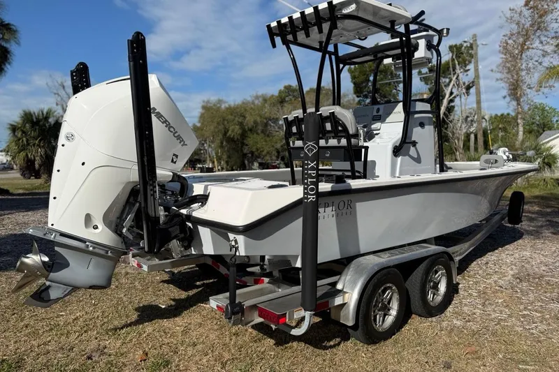 Slide: The Image of 2024 Xplor X24 boat on trailer with Mercury engine, parked outdoors. - 7