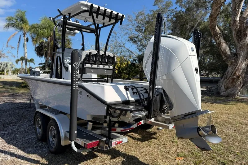 Slide: The Image of 2024 Xplor X24 boat on trailer with powerful outboard motor, parked outdoors. - 9