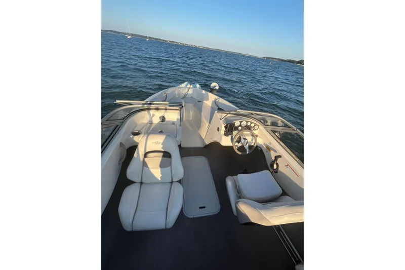 Slide: The Image of 2015 Stingray 191 RX boat interior with white seating on calm water. - 2