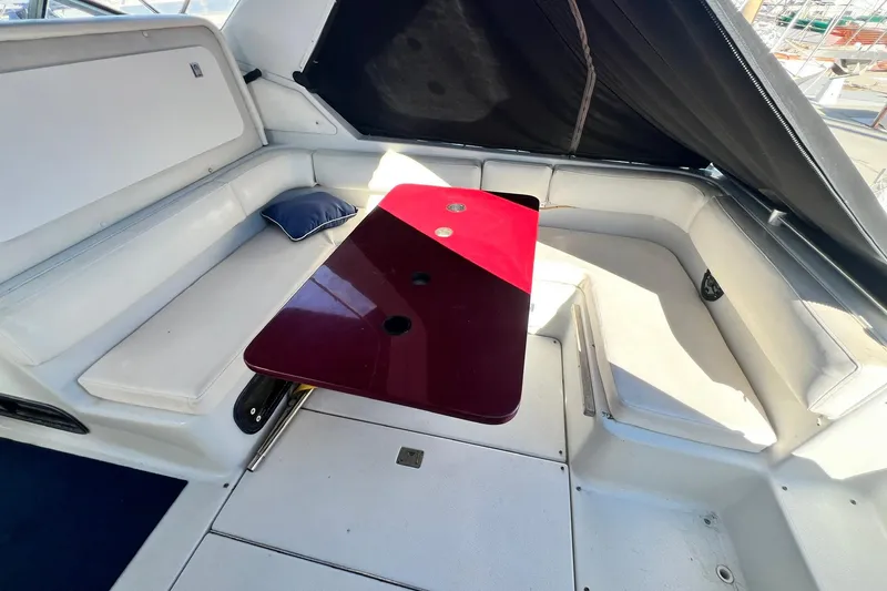 Slide: The Image of 1987 Chris-Craft 412 Amerosport interior with seating and table, featuring white upholstery. - 12