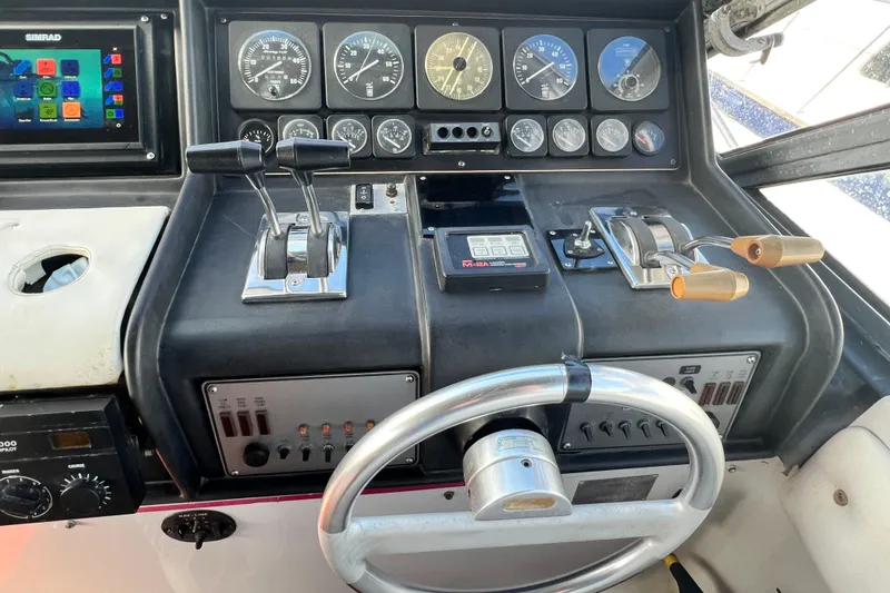 Slide: The Image of Control panel of a 1987 Chris-Craft 412 Amerosport boat with gauges and steering wheel. - 14