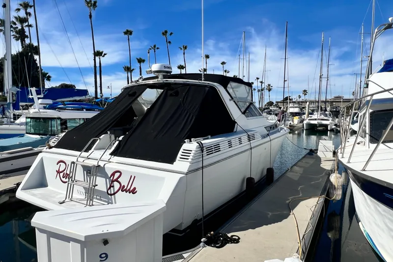 Slide: The Image of 1987 Chris-Craft 412 Amerosport yacht docked at marina under clear blue sky. - 2