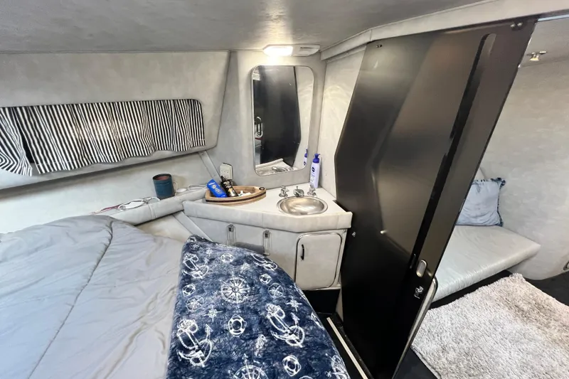 Slide: The Image of 1987 Chris-Craft 412 Amerosport cabin interior with bed, sink, and nautical decor. - 33