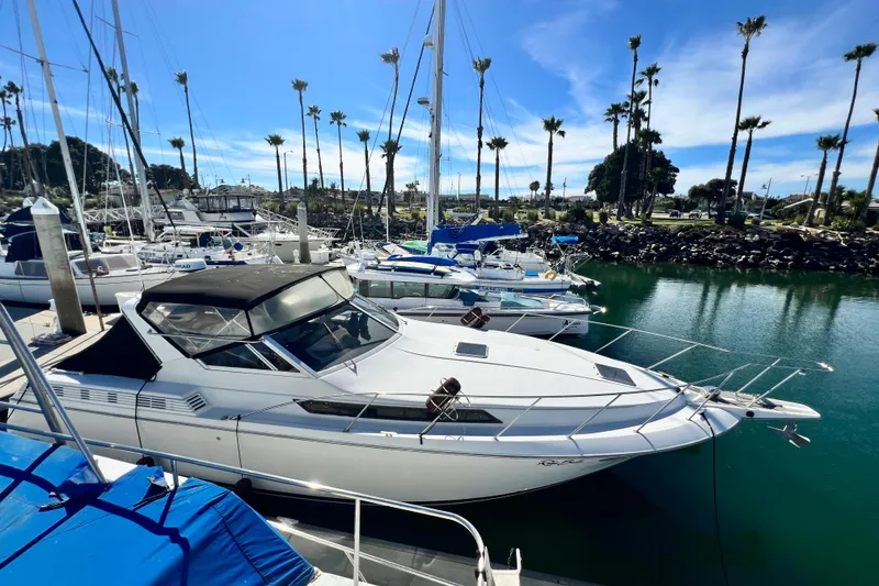 Slide: The Image of 1987 Chris-Craft 412 Amerosport yacht docked at marina under clear blue sky. - 4