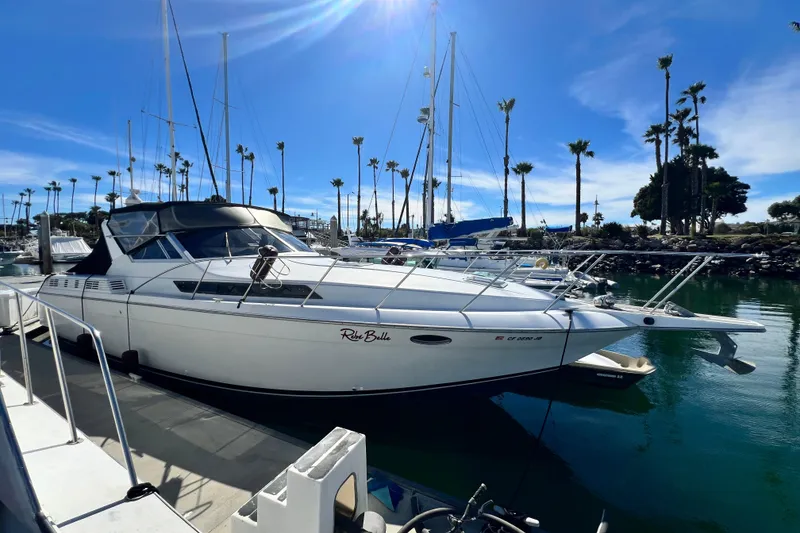 Slide: The Image of 1987 Chris-Craft 412 Amerosport yacht docked in a sunny marina with palm trees. - 5