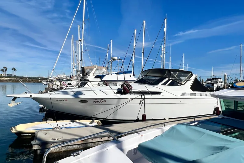 Slide: The Image of 1987 Chris-Craft 412 Amerosport yacht docked at marina under clear blue sky. - 7