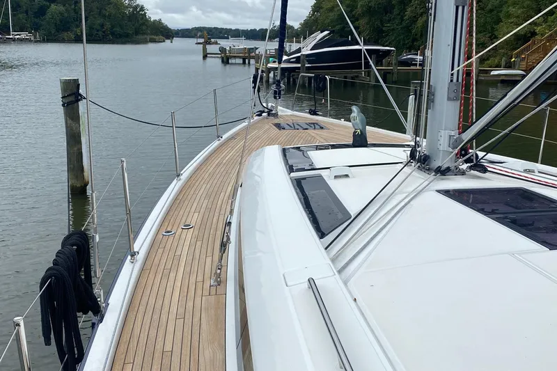Slide: The Image of 2019 Beneteau Oceanis 51.1 sailboat docked on a serene river. - 10