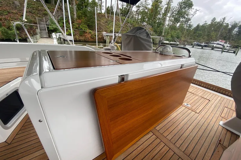 Slide: The Image of 2019 Beneteau Oceanis 51.1 yacht deck with wooden table and scenic marina view. - 12