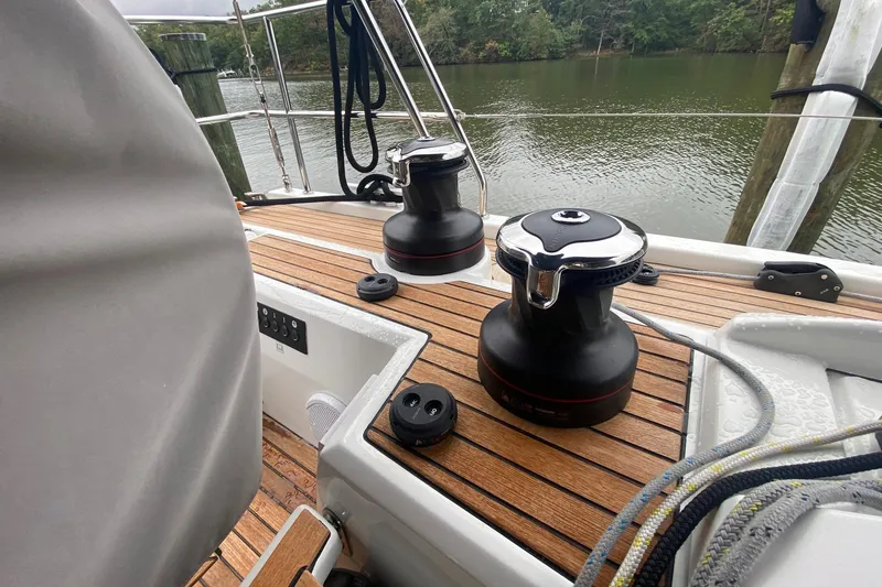 Slide: The Image of 2019 Beneteau Oceanis 51.1 sailboat deck with winches and ropes by the water. - 24