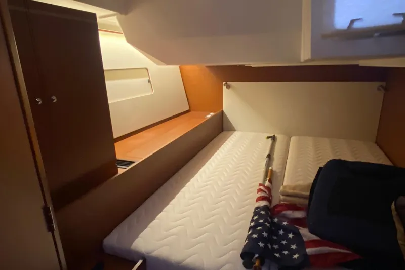 Slide: The Image of Interior cabin of 2019 Beneteau Oceanis 51.1 yacht with bed and American flag. - 41